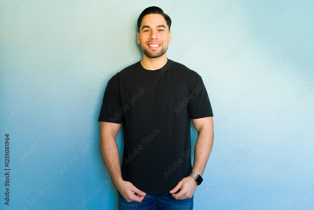 Handsome hispanic man smiling and posing on blue background Handsome hispanic man smiling and posing on blue background