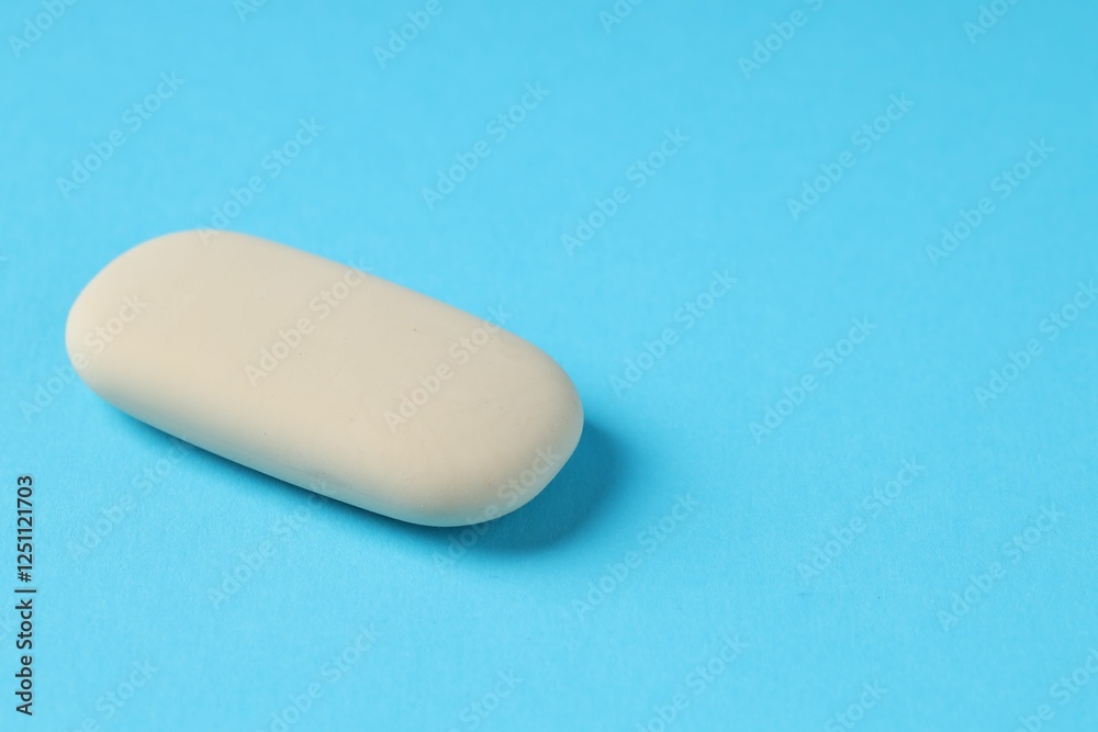 One eraser on light blue background, closeup. Space for text One eraser on light blue background, closeup. Space for text