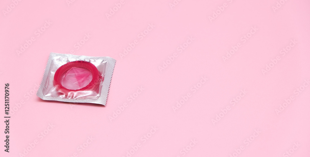 Pink condom isolated on pink background, Having safe sex for Valentine's Day Pink condom isolated on pink background, Having safe sex for Valentine's Day