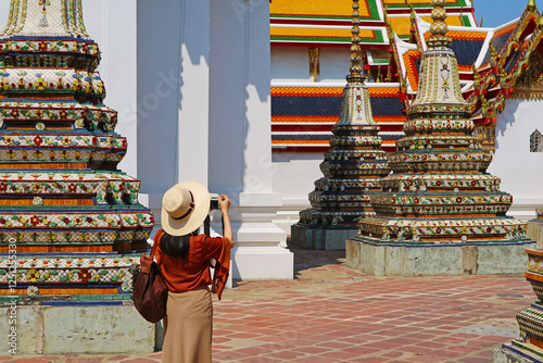 Female Visitor at The Courtyard of Temple of Reclining Buddha or Wat Pho, Located in Rattanakosin Island, Bangkok, Thailand photo
