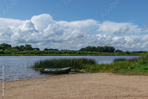 boat in the water by the river in summer with clouds in the sky