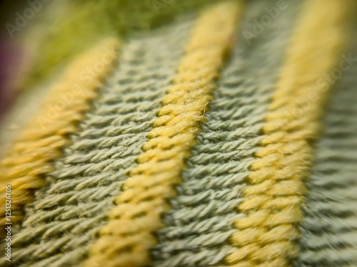 Close-up of woven fabric showing vibrant yellow and green threads. Ideal for fashion, textiles, or craft projects. photo