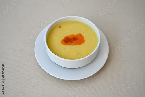 Lentil ( mercimek corbasi ) soup with melted butter and red pepper sauce. Limon ve soslu mercimek corba. photo