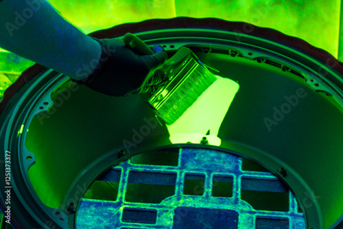 Fluorescent Penetrant Testing Application Using Brush on Industrial Component. NDT inspector applies liquid penetrant under UV light for surface defect detection