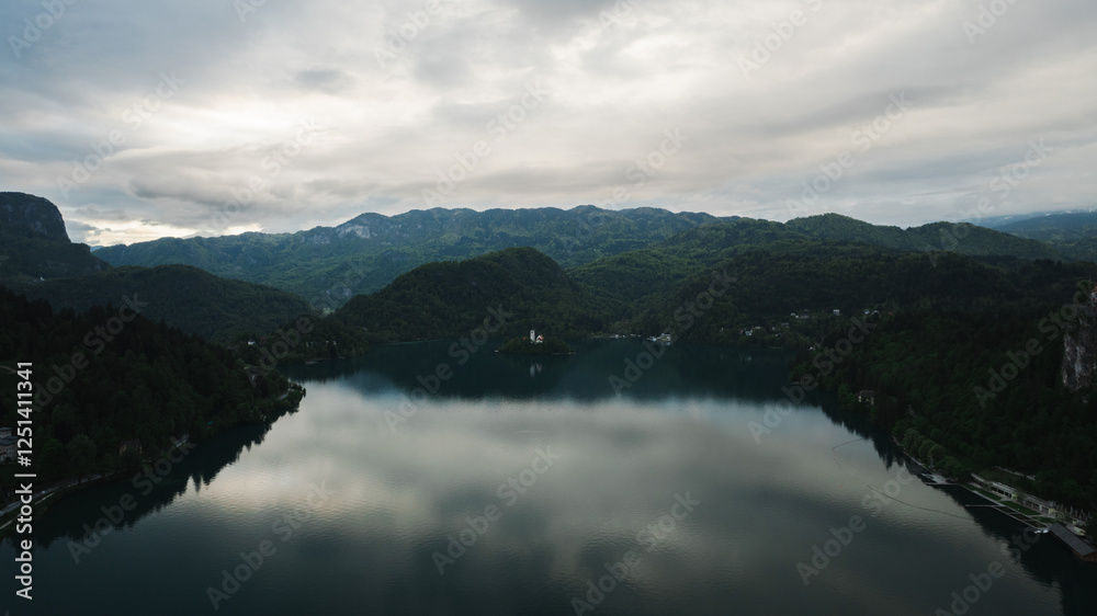 Obraz premium Aerial view of Church of the Assumption of Mary in the center of the lake Bled. Flying around small island on Bled Lake in Slovenia