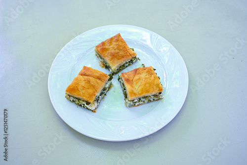 Turkish style meat stuffed filo dough borek served kol boregi. Cheese and minced pie are sliced on a marble background.  Avci boregi.Turkish name: Kol Boregi. Kiymali, peynirli su boregi. photo