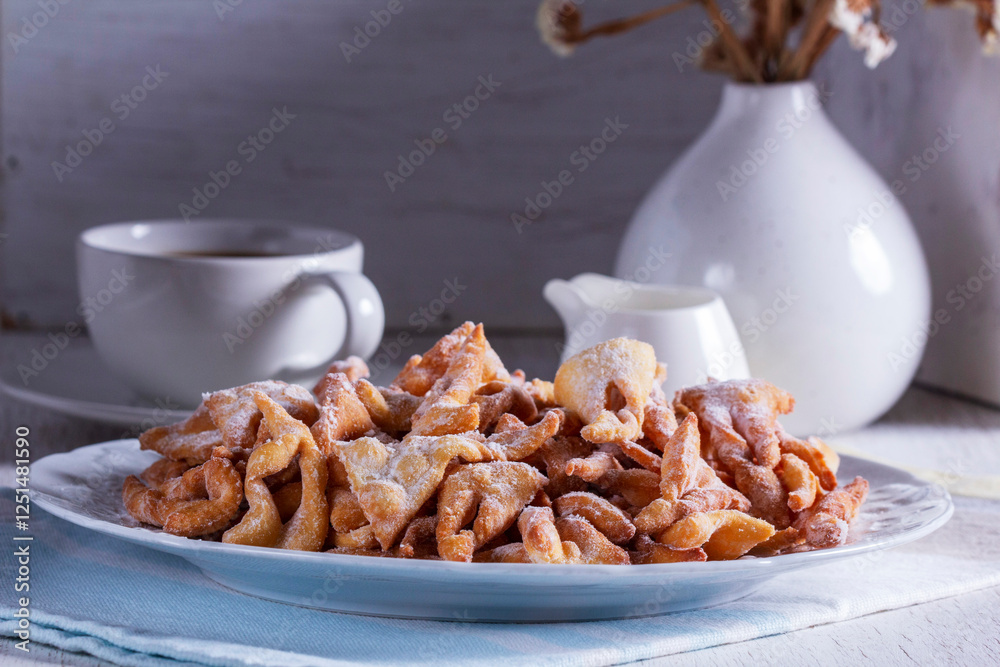 Traditional Maslenitsa dessert angel wings served with coffee on a light background.