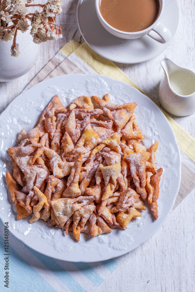 Traditional Maslenitsa dessert angel wings served with coffee on a light background.