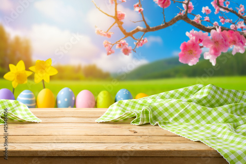Photography Easter holiday concept with empty wooden table, tablecloth and easter eggs over