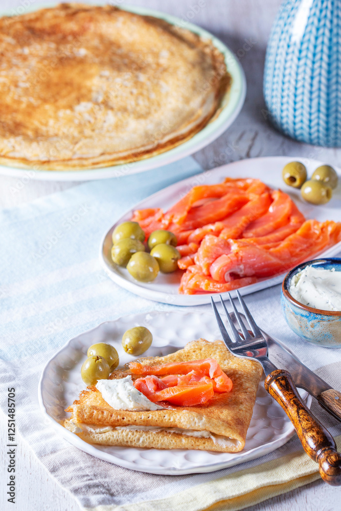 Pancakes with gravlax, cottage cheese and olives. A traditional dish for Maslenitsa or Carnival.