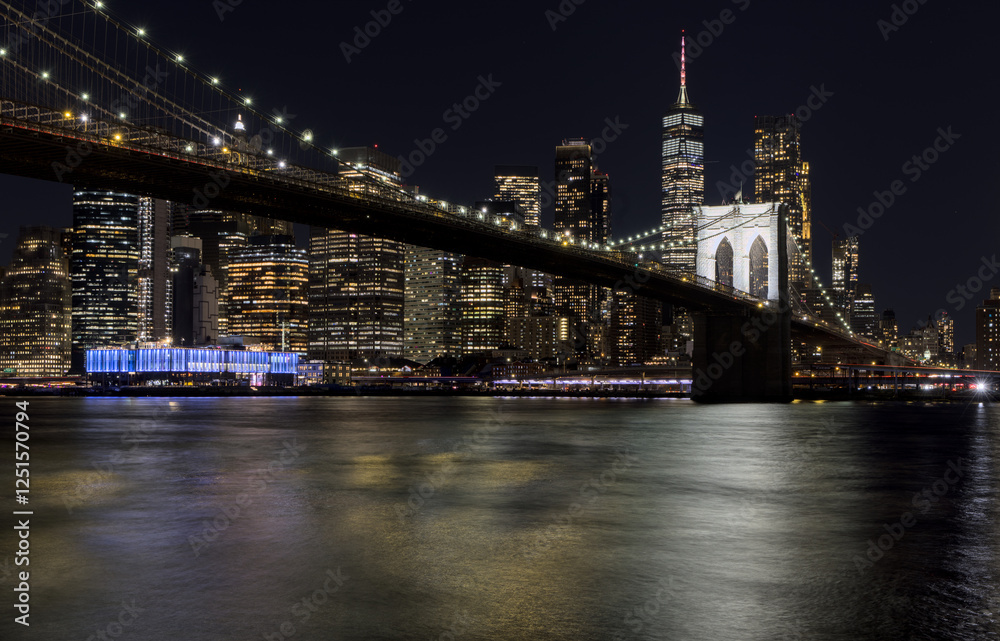 Obraz premium downtown manhattan new york city skyline with brooklyn bridge in the foreground at night (east river long exposure in dark darkness) lights office buildings skyscrapers travel tourism destination usa