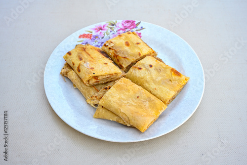Freshly baked appetizing Turkish tortillas - Gozleme with spinach, cheese  on a white board. Space for text. Handmade Turkish traditional pastries. Ispanakli, otlu peynirli gozleme. Tahinli Katmer photo