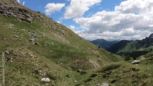 A dirt path hugs the contour of a majestic hill, weaving through an awe-inspiring Dolomite landscape that promises endless discovery.