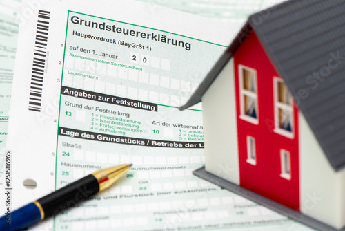 Obraz na płótnie Ein Modellhaus steht auf einem Formular zur Grundsteuererklärung für das Finanzamt w salonie