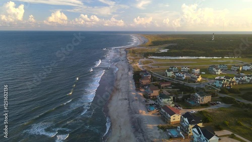 Cape Hatteras at Sunset. The Atlantic Ocean shore, hotels, villas and the Cape Hatteras Lighthouse.

