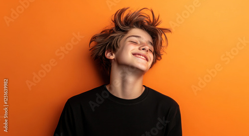 Joyful boy with messy hair smiles brightly, capturing the essence of happiness in a warm, vibrant atmosphere filled with energy photo