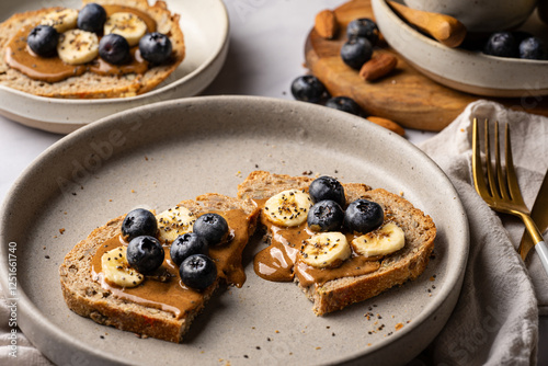 artisanal sourdough toast with almond butter, banana, blueberries, and chia seeds. A healthy, nutritious breakfast ideal for clean eating and balanced diets.