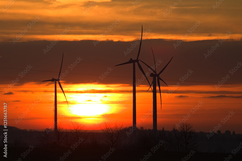 Obraz premium Wind power plant landscape at sunset time with dramatic sky.Wind farm at sunset. Pure energy, wind turbine. Wind turbines farm. Sunset Landscape.