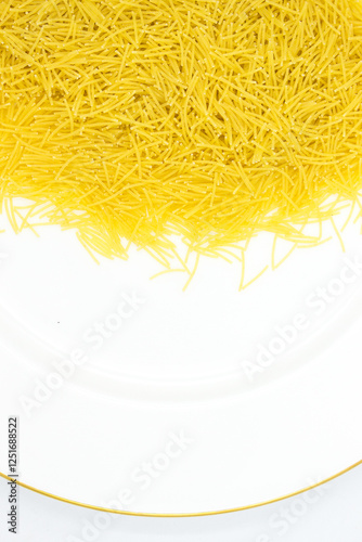 Uncooked vermicelli Pasta with Copy Space on on a white plate with a gold border. Raw and Dry vermicelli.