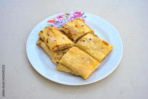 Freshly baked appetizing Turkish tortillas - Gozleme with spinach, cheese  on a white board. Space for text. Handmade Turkish traditional pastries. Ispanakli, otlu peynirli gozleme. Tahinli Katmer photo