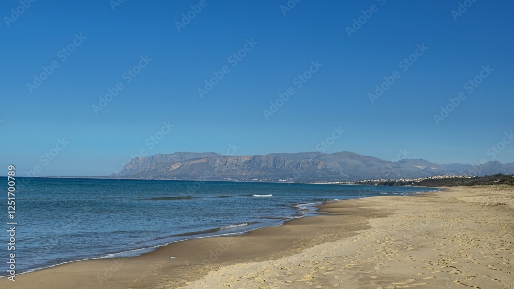 Sandy beach with small waves against the backdrop of the azure sea and mountains Sandy beach with small waves against the backdrop of the azure sea and mountains