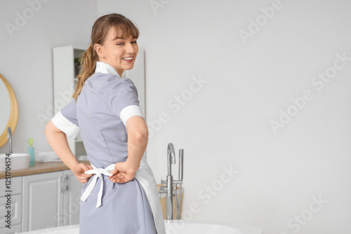 Smiling young housekeeper t...