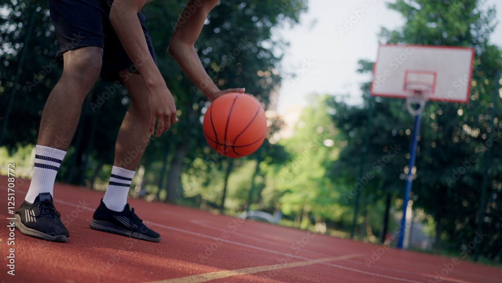 Close-up of a Black basketball player dribbling the ball outdoors, promoting sports education Close-up of a Black basketball player dribbling the ball outdoors, promoting sports education