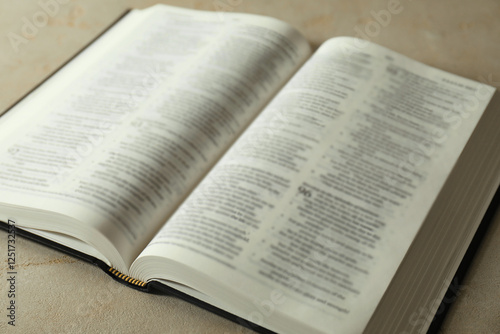 Open Holy Bible in English language on grey table, closeup photo