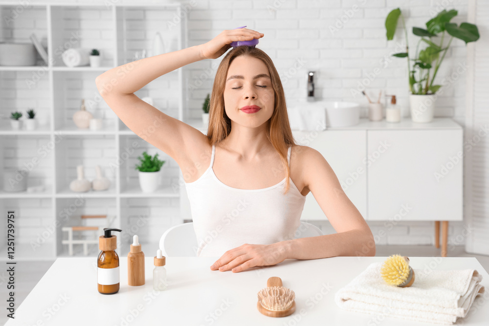 Young woman using hair scalp massager at home Young woman using hair scalp massager at home