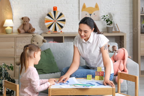 Female speech therapist with little girl pronouncing letter C in office photo