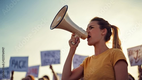 Woman activist passionately speaking with a megaphone in a crowd protest