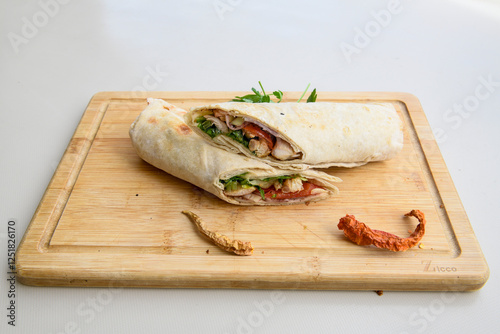 Lavash doner kebab ( soslu kasarli zurna doner durum )  or shawarma sliced in plate isolated.  Tavuk Et Doner Durum. Hatay Iskenderun usulu bazuka tavuk doner durum.  photo