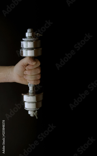 Obraz na płótnie Hand gripping shiny dumbbell against dark background w salonie