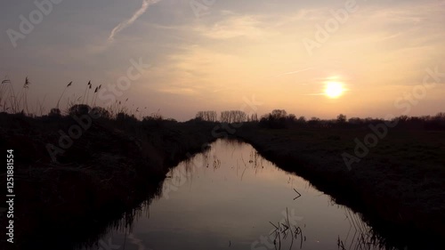 drone shot over a river with sunset in the backround