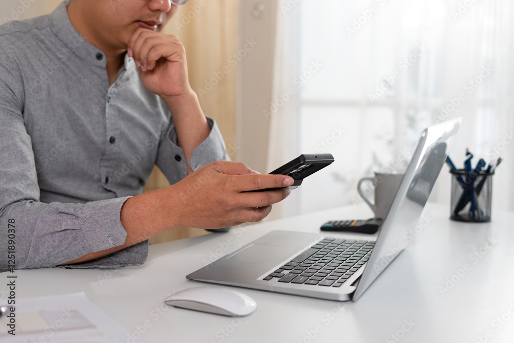 Working man using a telephone on a white desk Working man using a telephone on a white desk