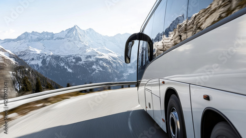 A bus navigates a winding road through stunning mountainous terrain. Snow-capped peaks surround the route, showcasing the beauty of nature in bright daylight photo