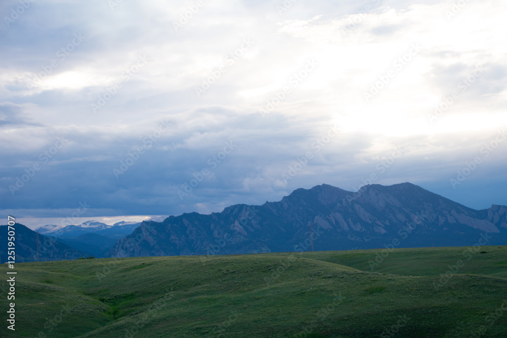 Green rolling hills with mountains in the distance Green rolling hills with mountains in the distance