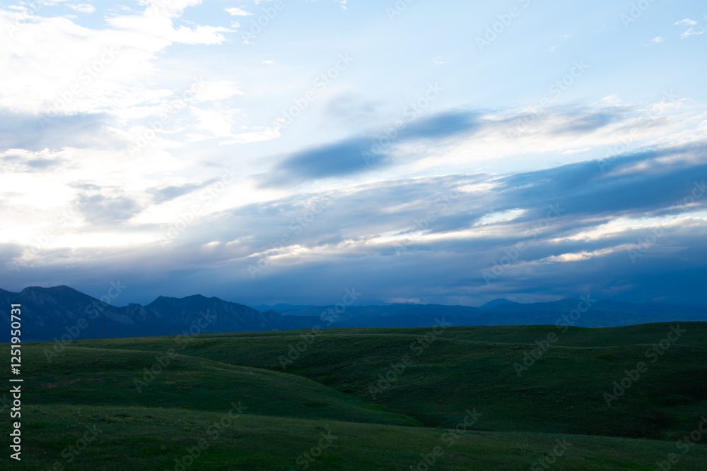 Green rolling hills with mountains in the distance Green rolling hills with mountains in the distance