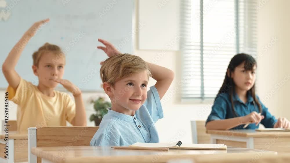 Caucasian boy raising hand for asking and answering teacher surrounded by diverse children studying at classroom. Happy student working together, voting, volunteering, calling instructor. Pedagogy. Caucasian boy raising hand for asking and answering teacher surrounded by diverse children studying at classroom. Happy student working together, voting, volunteering, calling instructor. Pedagogy.