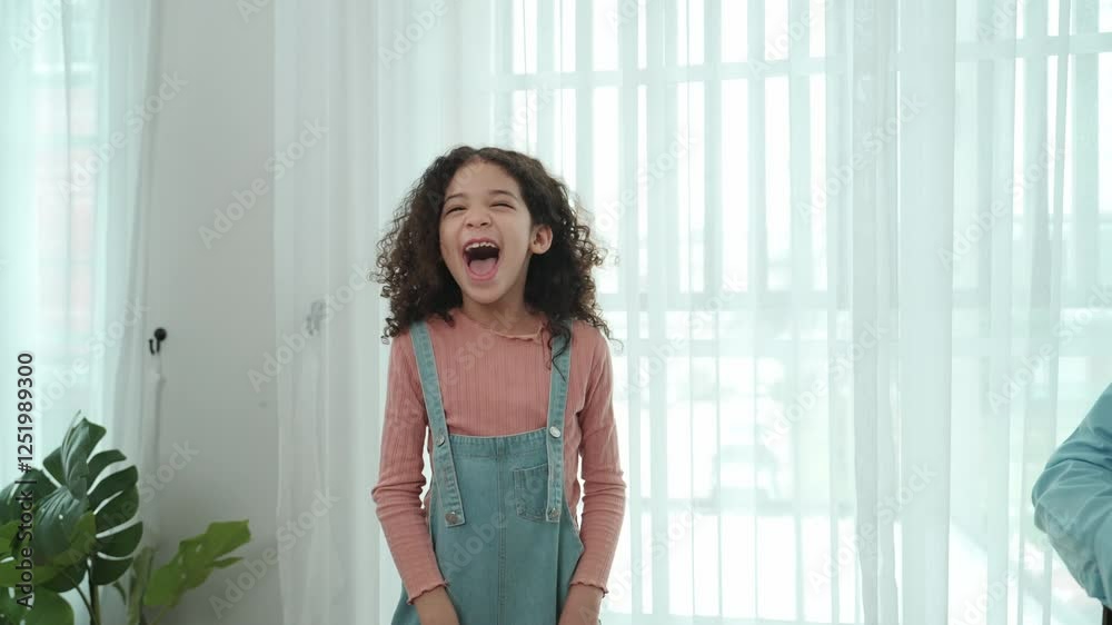 Caucasian dad playing guitar while cute daughter dancing and laughing to music. Happy father and american girl spend time together while smart child move to music. Family recreation concept. Pedagogy. Caucasian dad playing guitar while cute daughter dancing and laughing to music. Happy father and american girl spend time together while smart child move to music. Family recreation concept. Pedagogy.