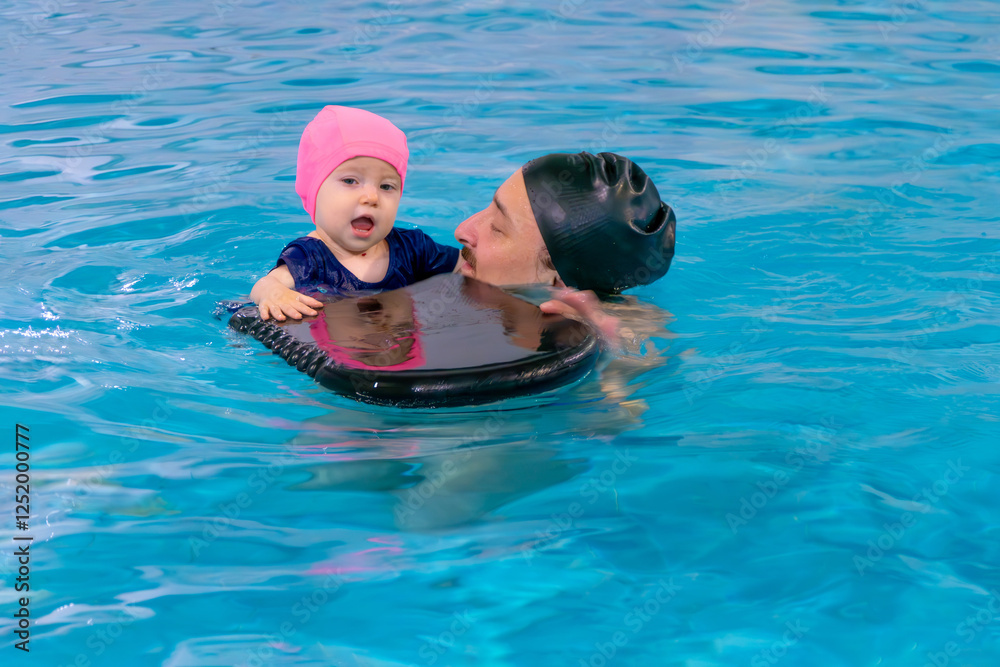 Happy middle-aged father swimming with cute adorable baby in swimming pool. Smiling dad and little child, girl having fun together. Active family spending leisure and time in spa hotel. Concept of