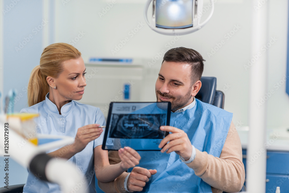 Dentist Discussing X-Ray Results with Patient in Clinic Dentist Discussing X-Ray Results with Patient in Clinic