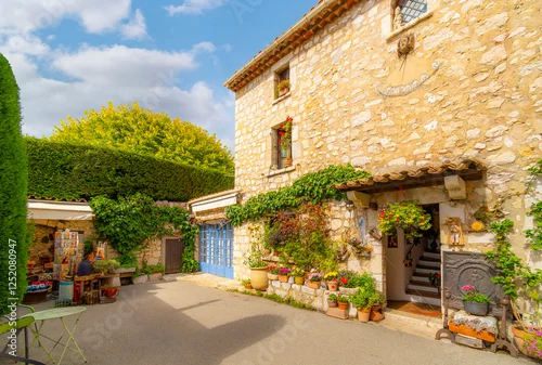 Obraz A small courtyard with souvenir stand and stone residential building in the historic medieval old town of Gourdon, France, in the Alpes-Maritimes region.