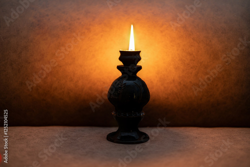 A candle with a candlestick on a brown background.