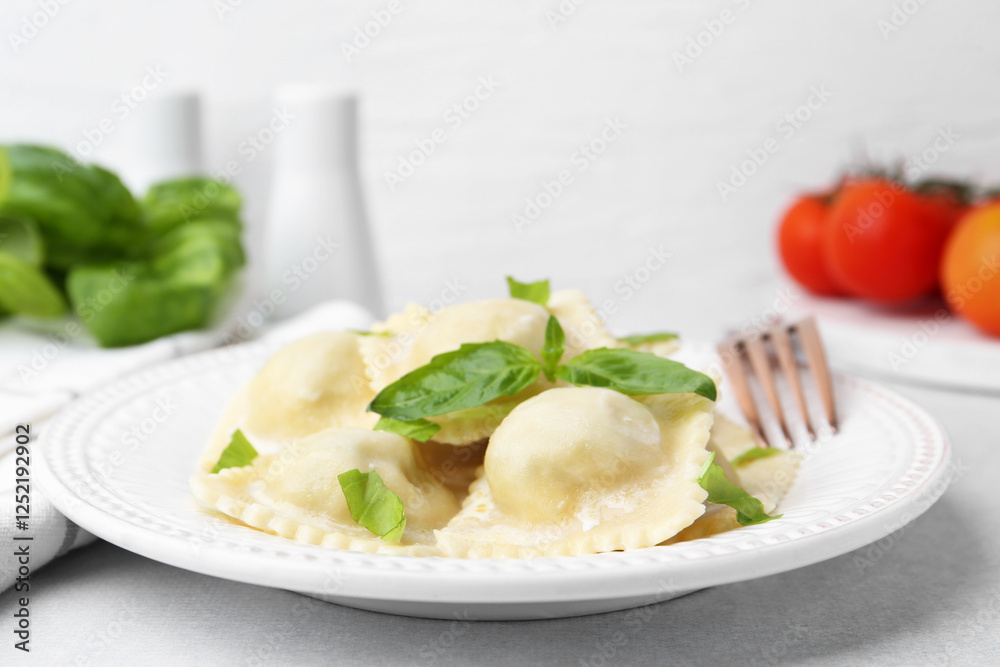 Delicious ravioli with cheese and basil served on light table, closeup Delicious ravioli with cheese and basil served on light table, closeup