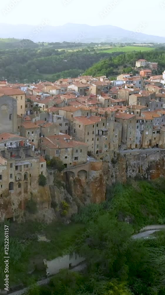 Aerial vertical view of Pitigliano town, located atop a volcanic tufa ridge, known as the little Jerusalem. Etruscan heritage, Grosseto, Tuscany, Italy. Aerial vertical view of Pitigliano town, located atop a volcanic tufa ridge, known as the little Jerusalem. Etruscan heritage, Grosseto, Tuscany, Italy.