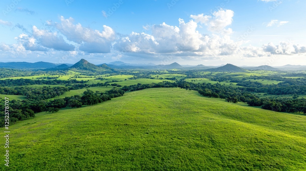 Fototapeta premium Panoramic view of rolling hills and lush green valleys under a partly cloudy sky. Possible use nature photography, travel brochure, tourism marketing