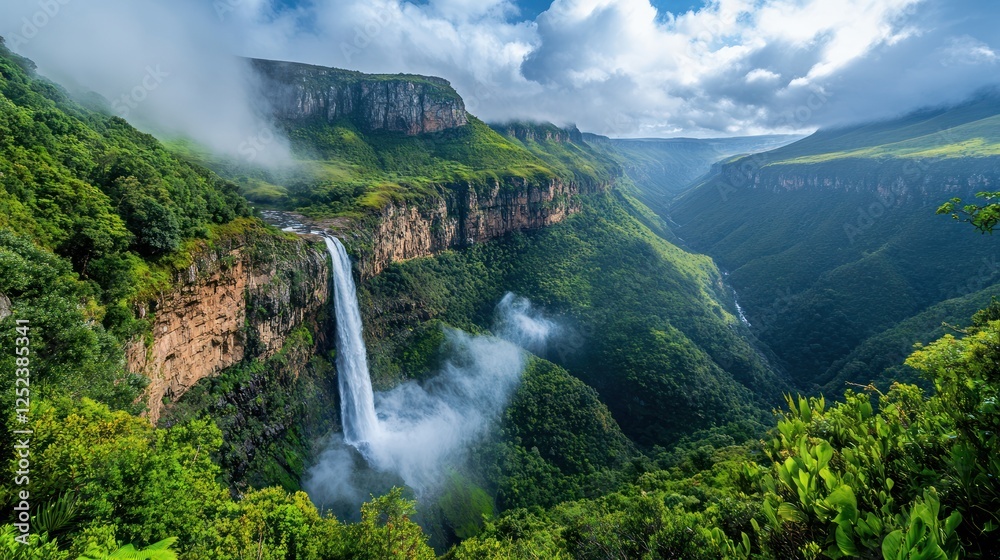 Fototapeta premium Majestic waterfall cascading down cliffs, lush green valley, misty mountains, travel background