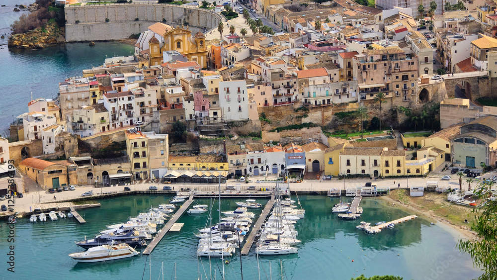 view of a coastal city with a harbor and yachts surrounded by mountains and green hills. Among the Mediterranean architecture, turquoise sea and cozy atmosphere. Italy, Sicily view of a coastal city with a harbor and yachts surrounded by mountains and green hills. Among the Mediterranean architecture, turquoise sea and cozy atmosphere. Italy, Sicily