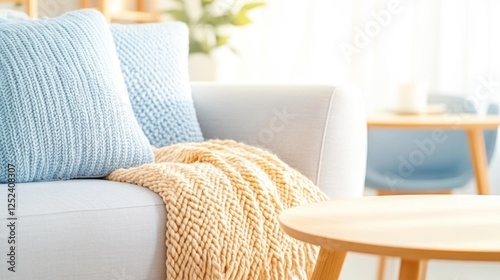 Cozy living room with knitted pillows and a soft blanket on a sofa featuring light colors and natural decor. Generative AI photo